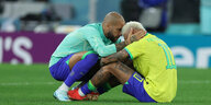 Dani Alves und Neymar trösten sich nach dem WM-Aus in Katar gegenseitig auf dem Rasen sitzend