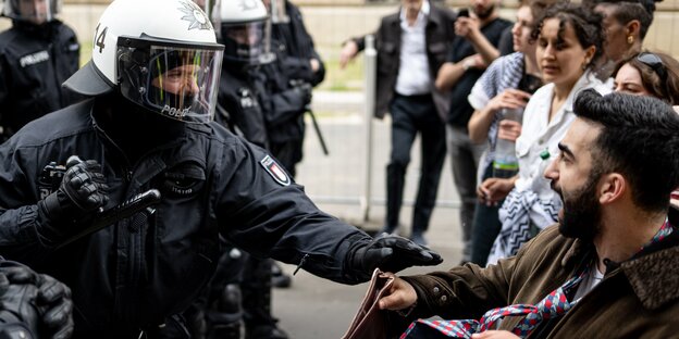 Ein Polizist und ein Demonstrant stoßen auf einer Demonstration nach der Auflösung der «Palästina Konferenz» in Berlin-Mitte zusammen.
