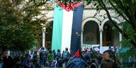 Eine riesige Palästina-Flagge hängt während der Kundgebung am Universitätsgebäude.