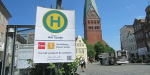 Ein Schild aus Pappe kündigt in der Lüneburger Innenstadt eine kommende Straßenbahn-Haltestelle an